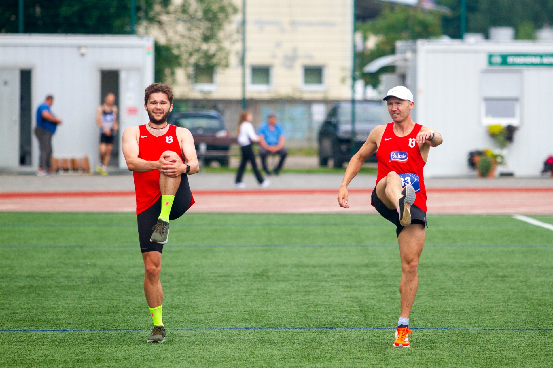 Two SK BULTA runners warming up on the field